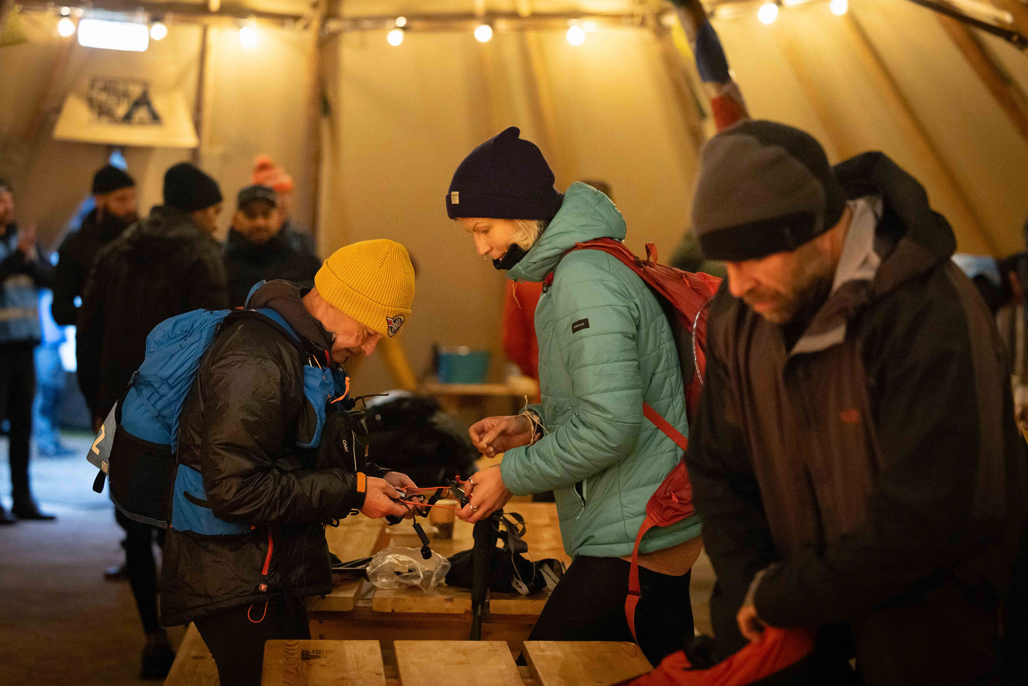 people preparing their hiking gear at APEX everest event inside a tent