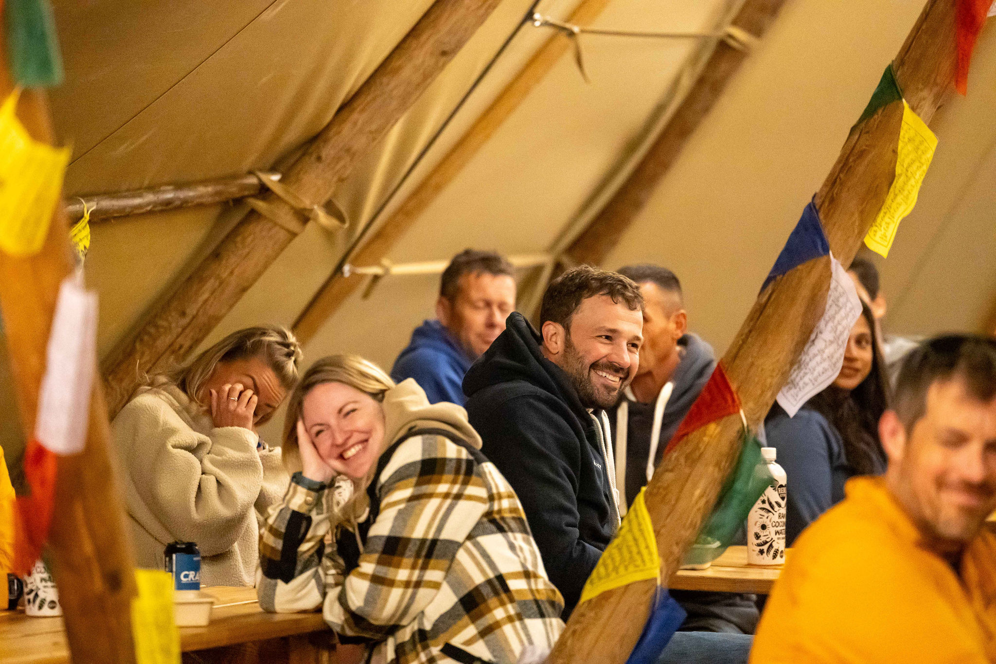 People smiling in base camp tent at APEX everest event