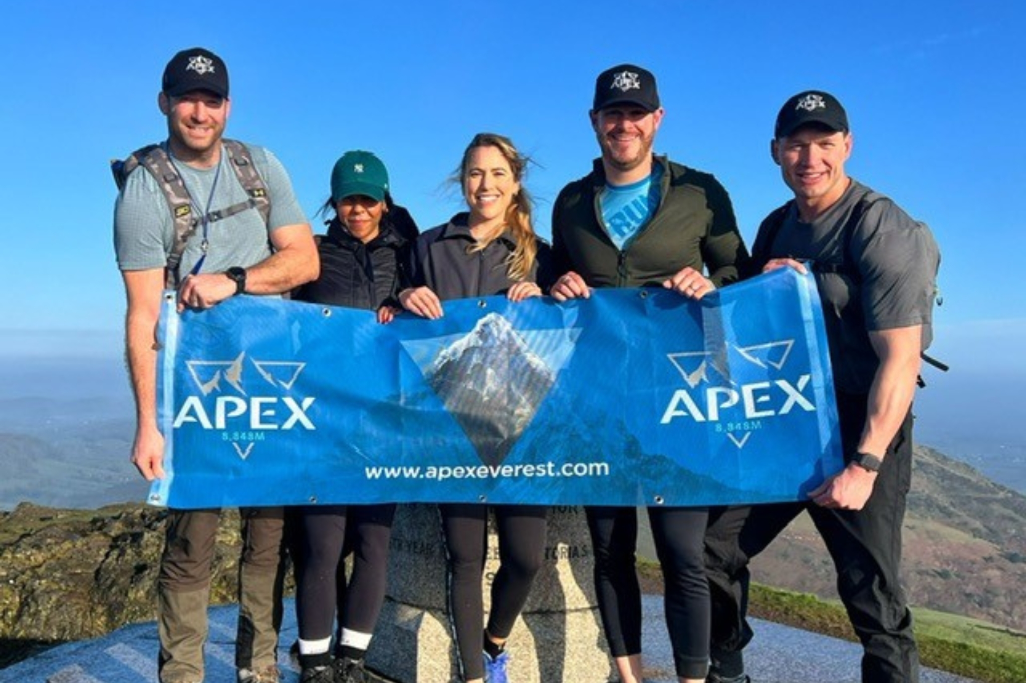 APEX everest hike club members with an advertisement banner at the top of helvellyn